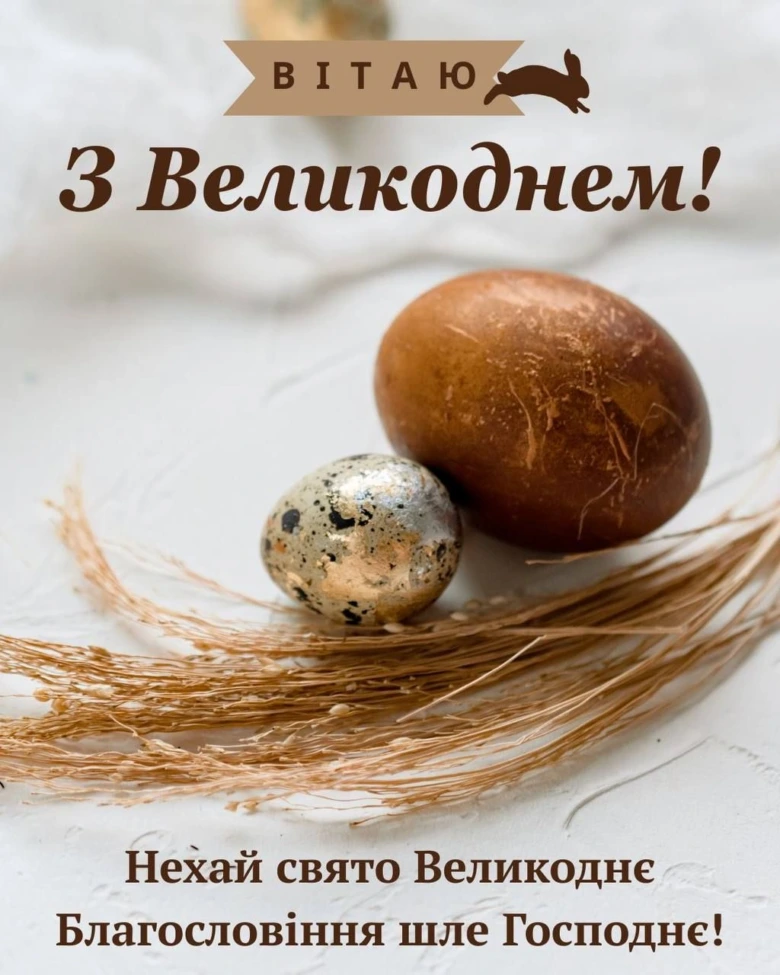 Два великодні яйця на сухій траві з привітанням.