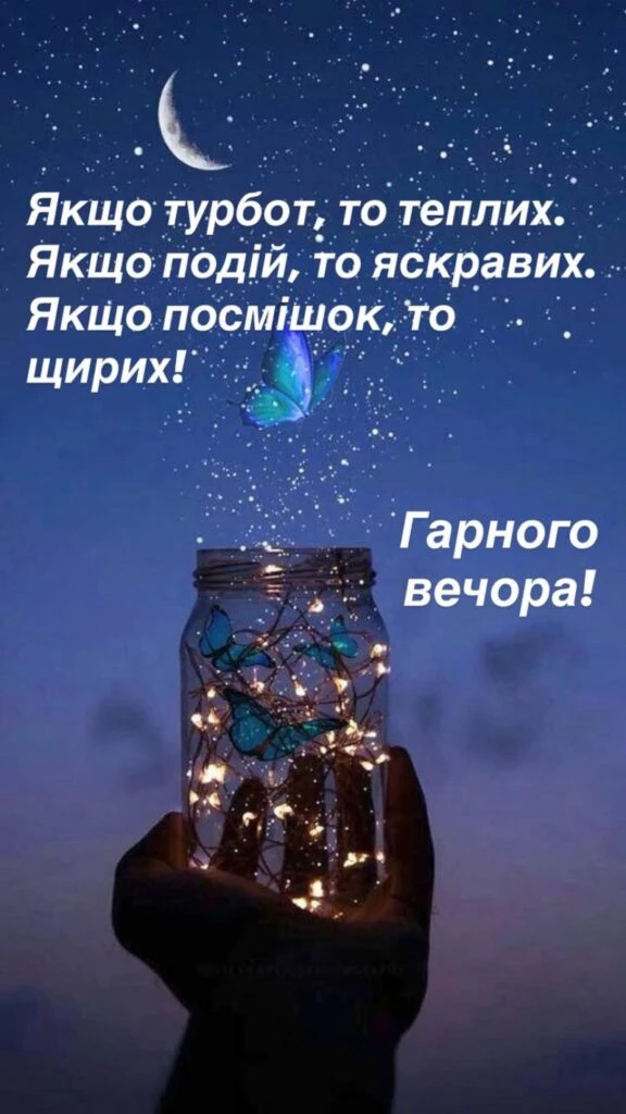 Рука тримає світлокулю з метеликами під нічним небом.
