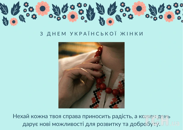 Жінка в вишиванці тримає червоні бусини на фоні квітів.