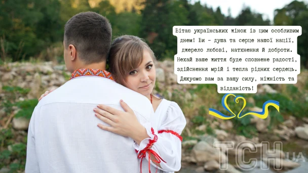 Чоловік обіймає жінку в українському одязі на фоні природи.