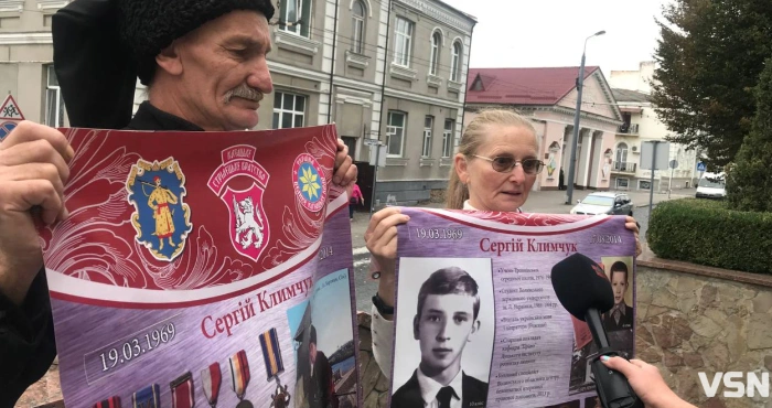 Люди тримають пам'ятні плакати про автора Сергія Клімчука.