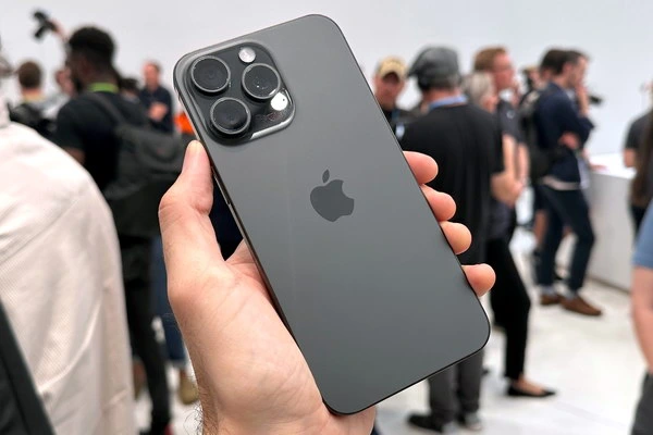 Чорний смартфон Apple в руках на фоні людей.