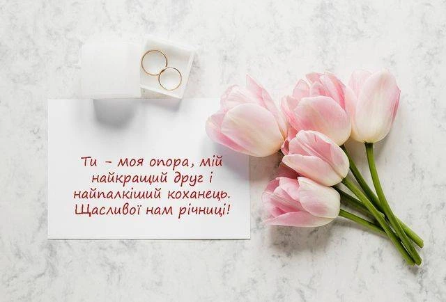 Розквітли тюльпани та обручальні кільця на картці з привітанням.