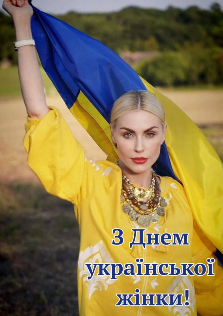 Жінка з прапором України на фоні природи.