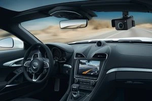 Внутрішній вигляд автомобіля з встановленим GPS-трекером на лобовому склі